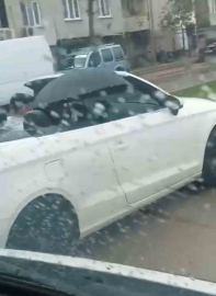 Milyonluk arabada ıslanmamak için şemsiye açtı