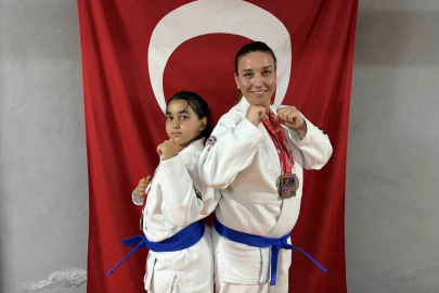 Anne ve kızı  minderde birlikte şampiyonluklara koşuyor
