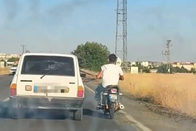 Otoyolda tehlikeli yolculuk: Motosiklet, otomobil kemerine tutunarak ilerledi

