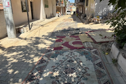 Mahalleli tozdan korunmak için onarılmayan yollara halı serdi