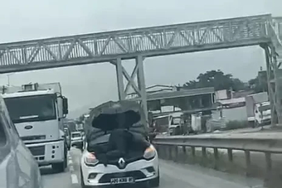 Otomobilin motorunun üzerinde seyahat etti; o anlar kamerada