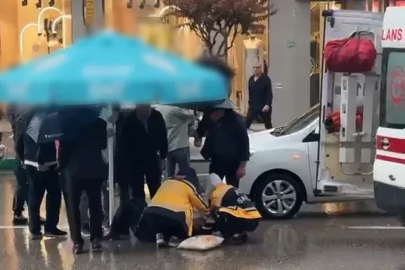 Otomobilin çarptığı yaralıyı yağmurdan korumak için şemsiye tuttular 
